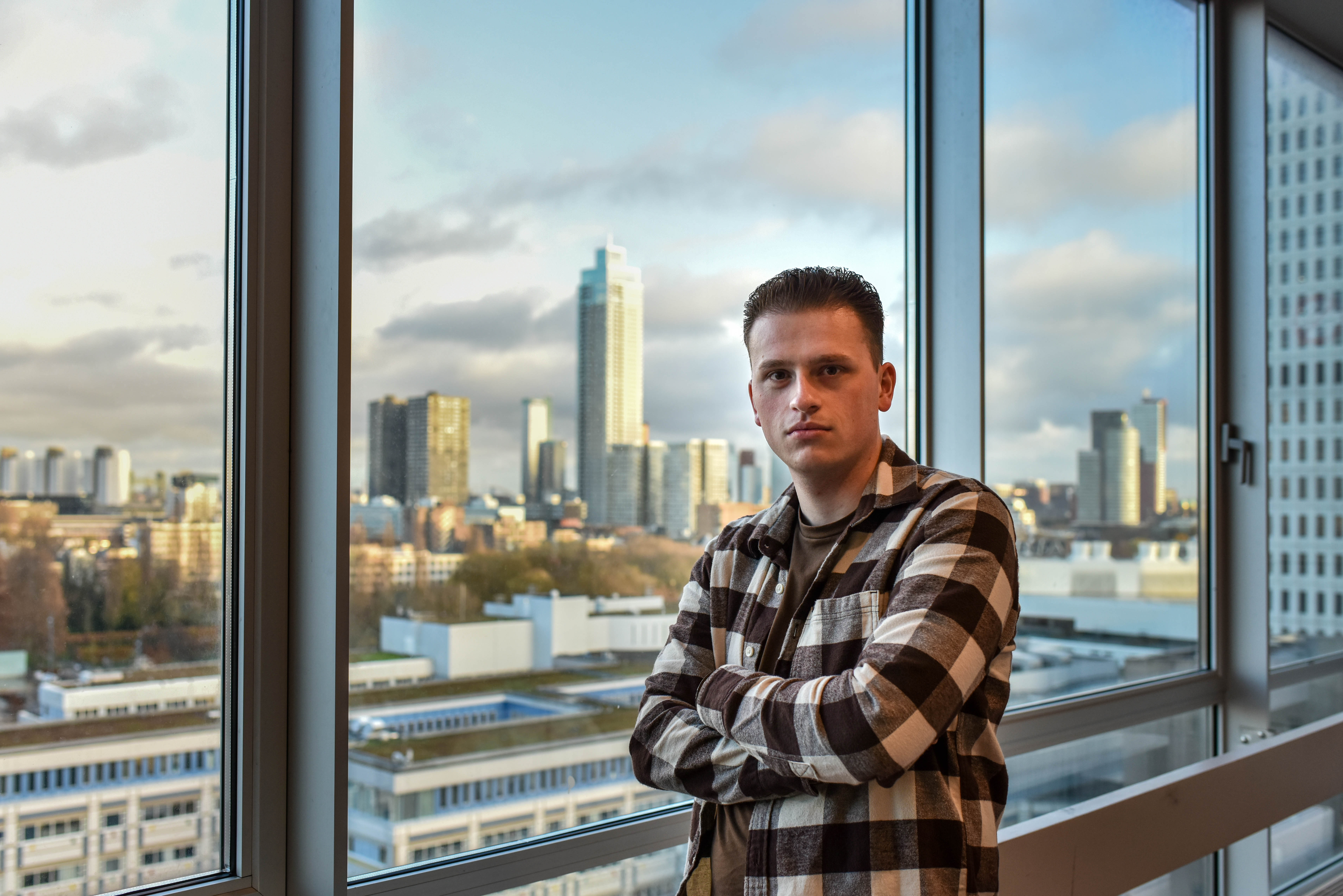 Jesper poseert met skyline van Rotterdam op de achtergrond
