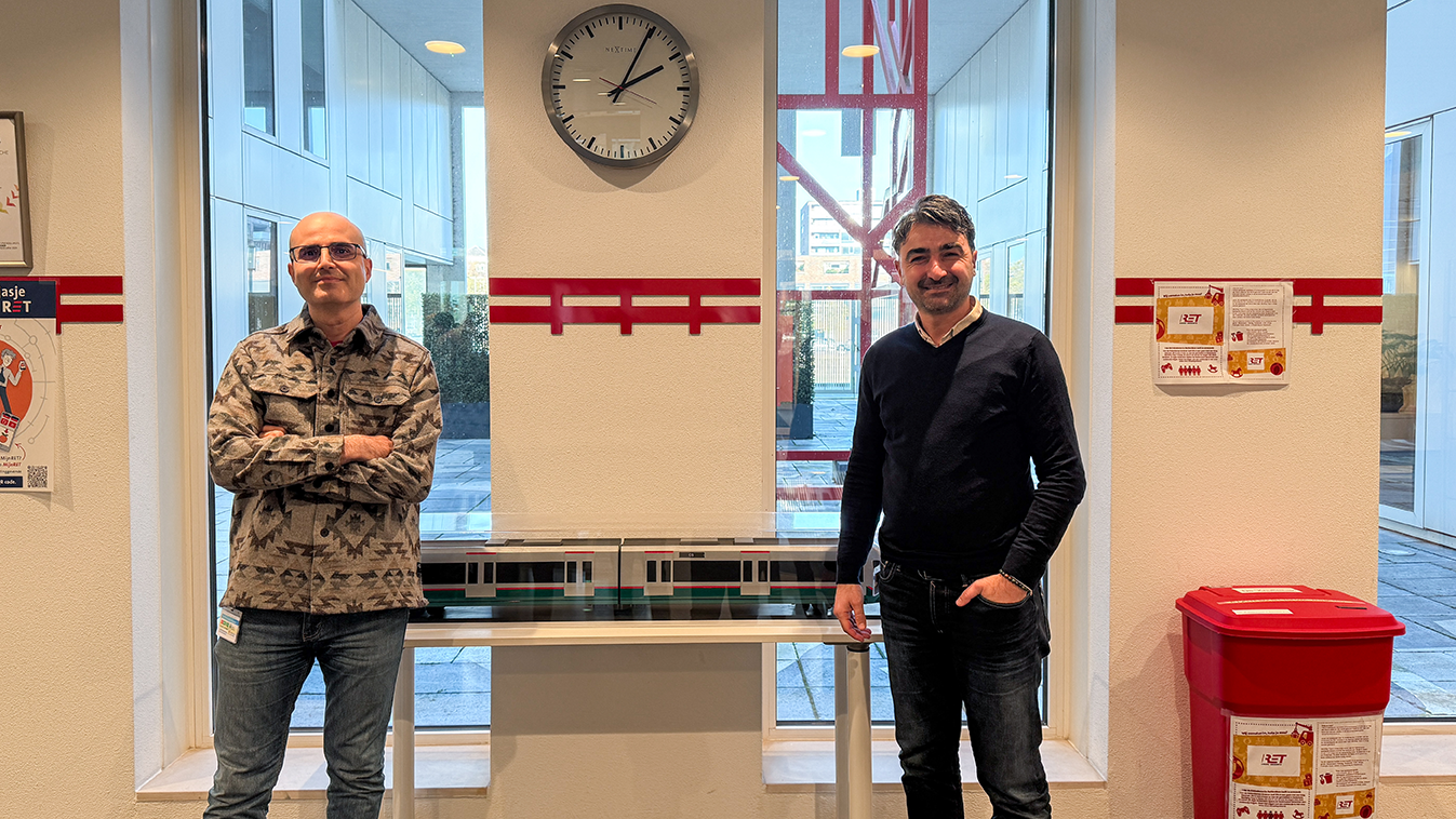 Amir en Selim poserend voor een schaalmodel metro van RET