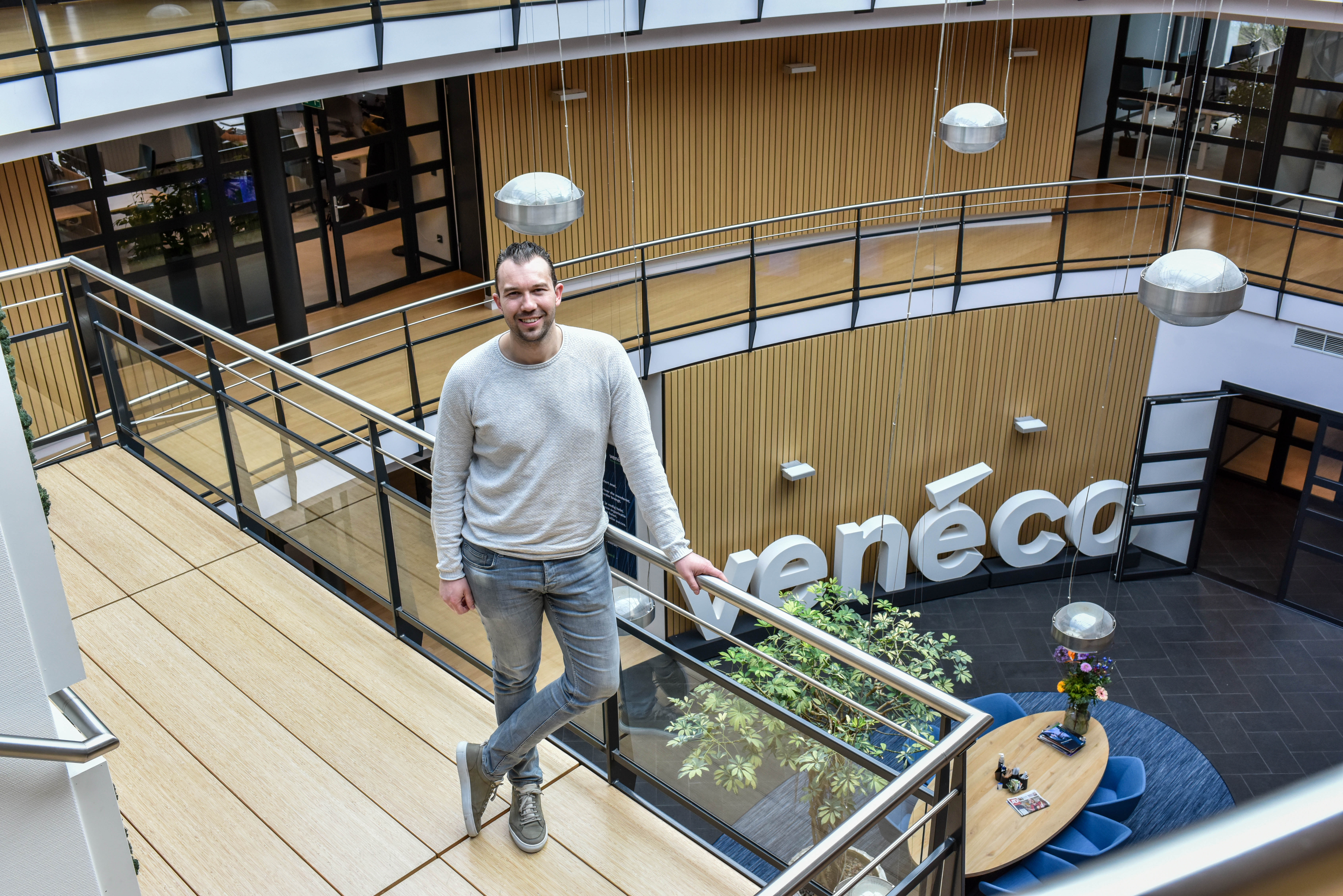 Bas Brusse poseert op een trap in het trappenhuis bij z'n werkgever Veneco